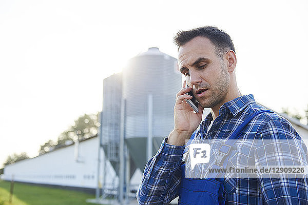 Farmer talking on cell phone on field