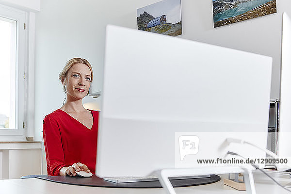 Portrait of young woman working on computer at desk in office