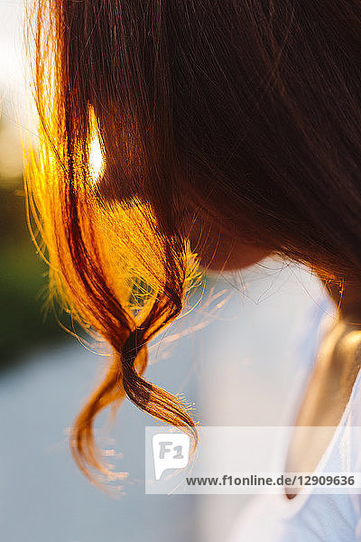 Profile of redheaded woman at backlight