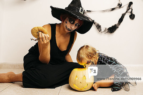 Mother and little daughter with Jack O'Lantern at home