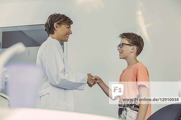 Boy greeting dentist  shaking hands