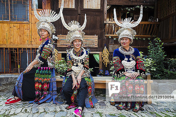 China  Guizhou  three Miao women wearing traditional dresses and headdresses