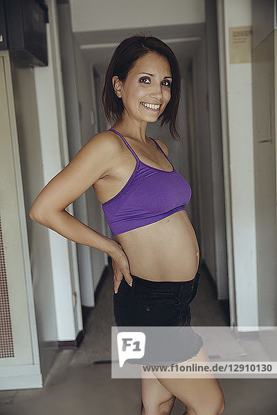 Portrait of smiling sporty pregnant woman standing
