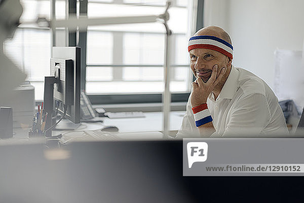 Businessman sitting in office  wearing sweat bands