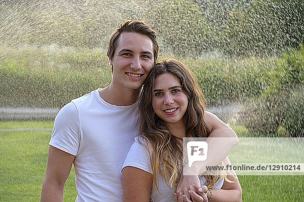 Young couple in summer standing on lawn