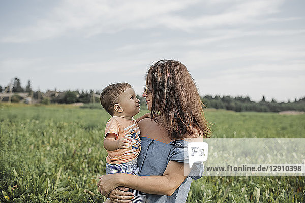 Mother holding baby on a field
