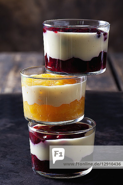 Red and yellow fruit compote with vanilla sauce layered in glasses