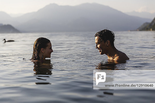 Happy young couple in a lake smiling at each other