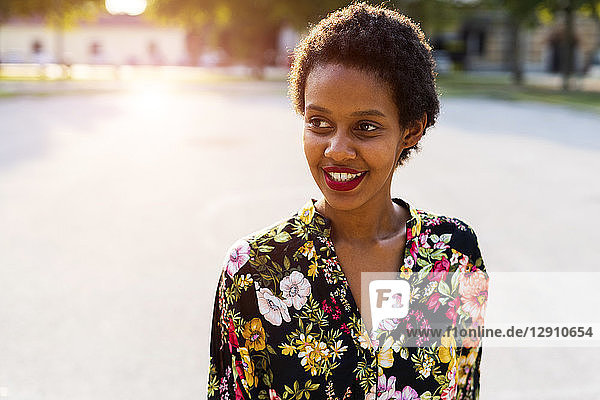 Portrait of smiling young woman outdoors at sunset