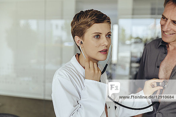 Female doctor examining patient with a stethoscope