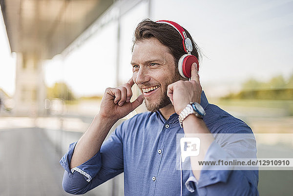 Portrait of happy man listening to music with headphones