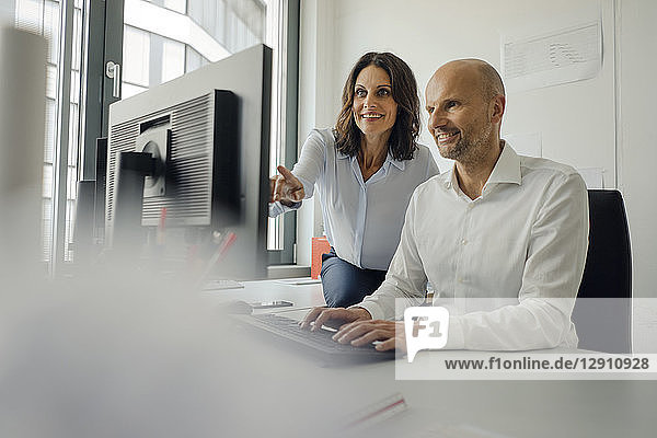 Businessman and woman working together in office