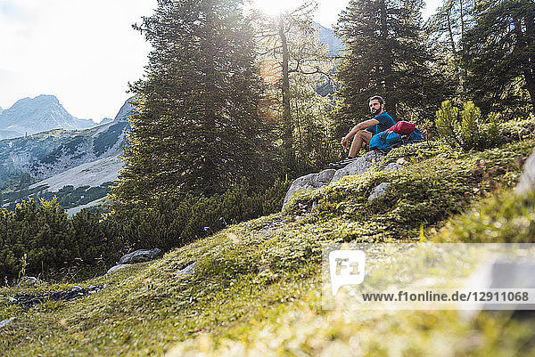 Austria  Tyrol  Hiker taking a break  sitting on a rock