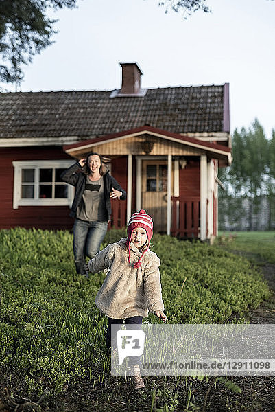 Finland  Kuopio  mother with daughter running at a cottage in the countryside