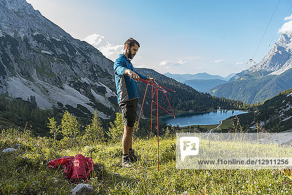 Austria  Tyrol  Hiker setting up his tent in the mountains at Lake Seebensee