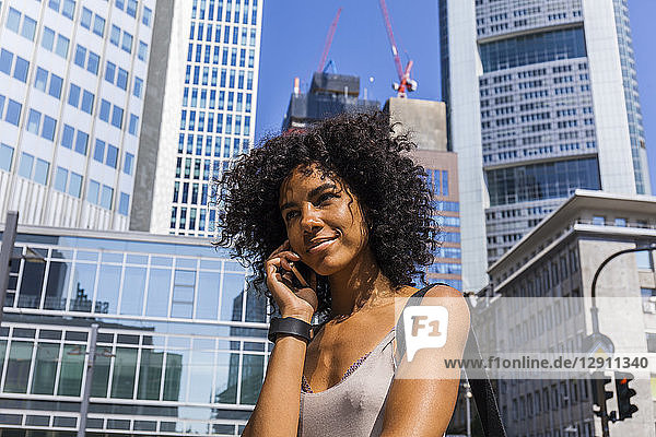 Germany  Frankfurt  portrait of smiling young woman on the phone
