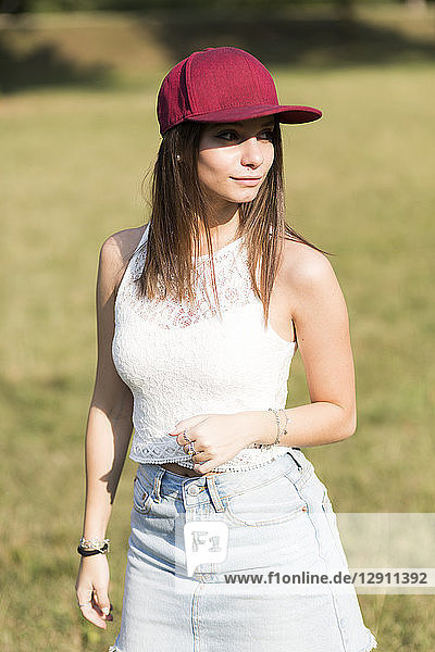 Young woman wearing baseball cap standing on a meadow