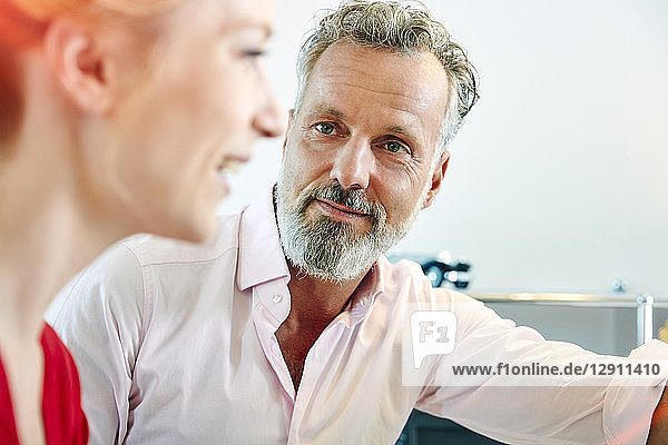 Mature man looking at female colleague in office