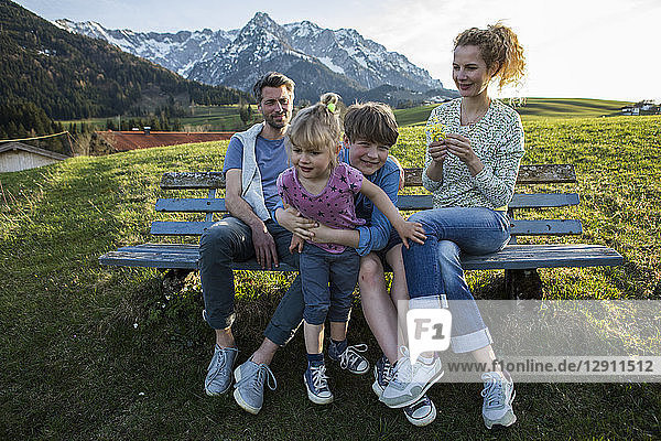 Austria  Tyrol  Walchsee  happy family resting on a bench in the mountains