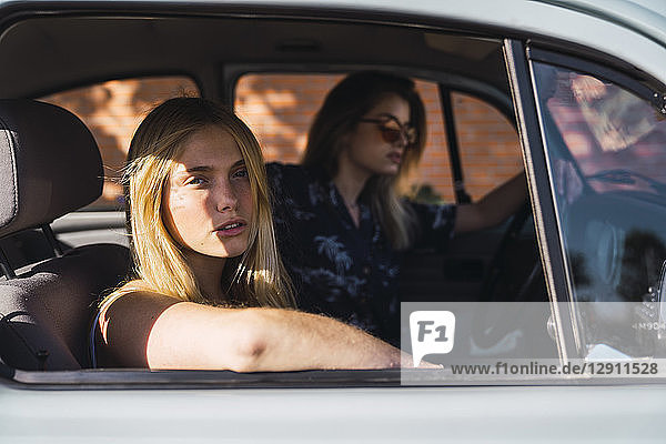 Portrait of young woman sitting in a car with friend