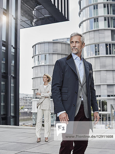 Germany  Duesseldorf  portrait of fashionable mature businessman in front of modern business building