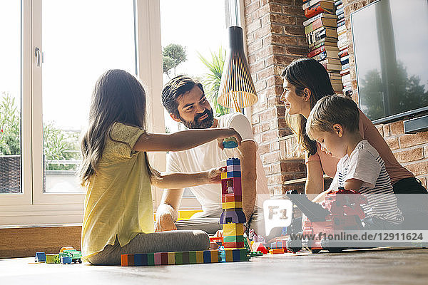 Family playing with building blocks on the floor together