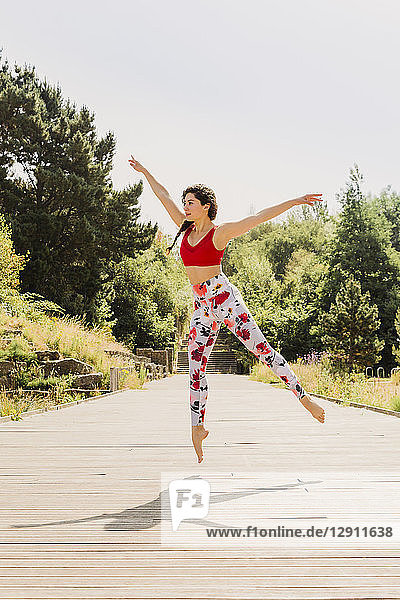 Young woman practicing Pilates in an urban park