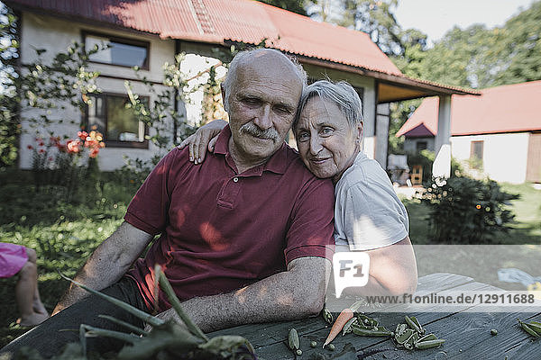 Portrait of senior couple sitting at garden table