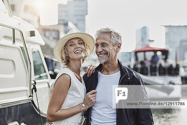 Older man and young woman at a marina next to a yacht