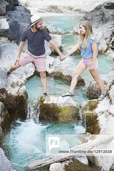 Young couple crossing river