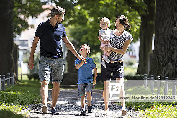 Happy family with two children walking in park