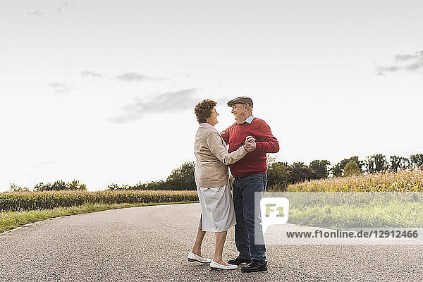 Senior couple dancing on country road