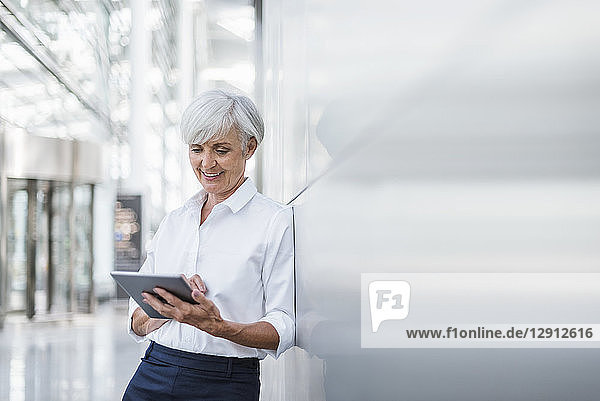 Smiling senior businesswoman using tablet