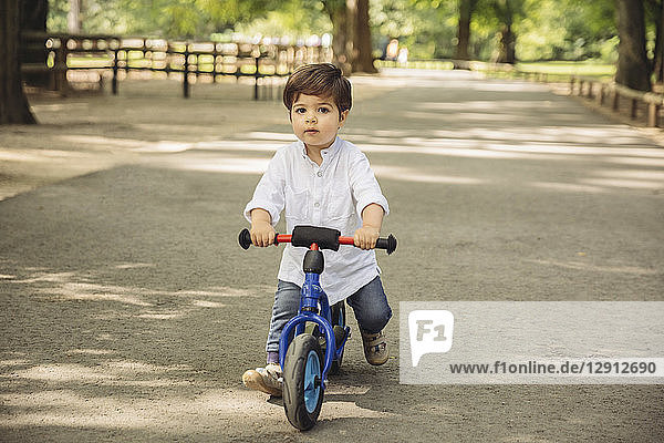 Toddler using a balance bicycle in wild park
