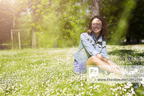 Smiling young woman sitting in a park
