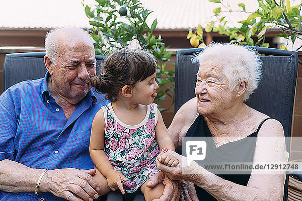 Grandparents and granddaughter spending time together on the terrace
