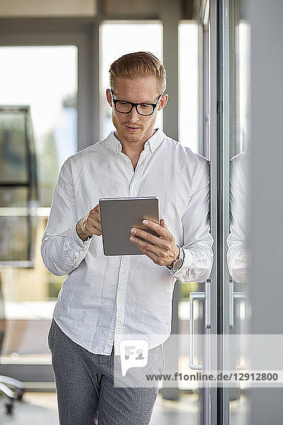 Businessman using tablet at the window in office