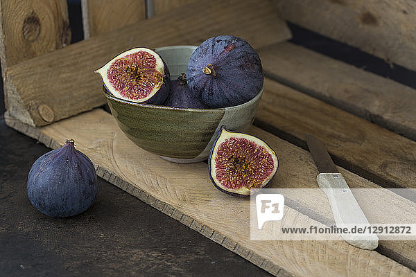 Sliced and whole fresh figs  kitchen knife and wooden box