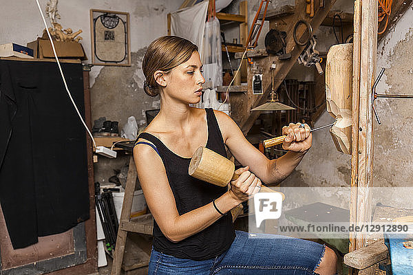 Sculptress carving wooden figure