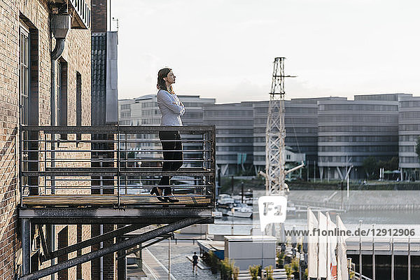 Businesswoman standing on a balcony  with eyes closed