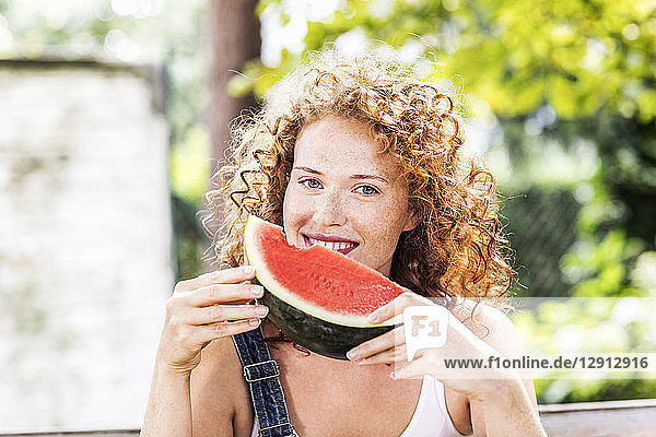 Portrait of redheaded young woman with watermelon