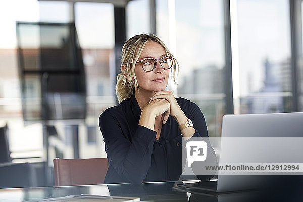Businesswoman sitting at desk  thinking