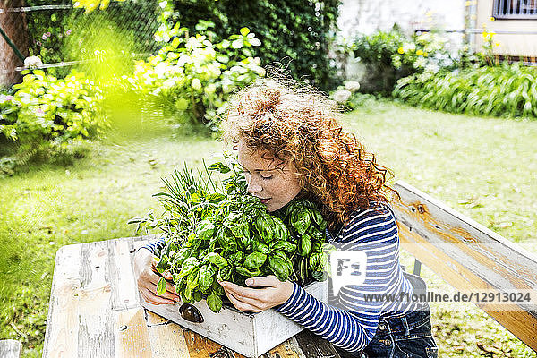 Portrait of young woman with fresh herbs in a box