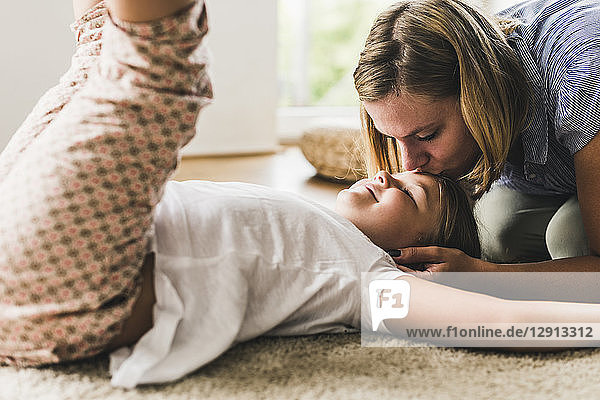 Mother and daughter playing with daughter in living room