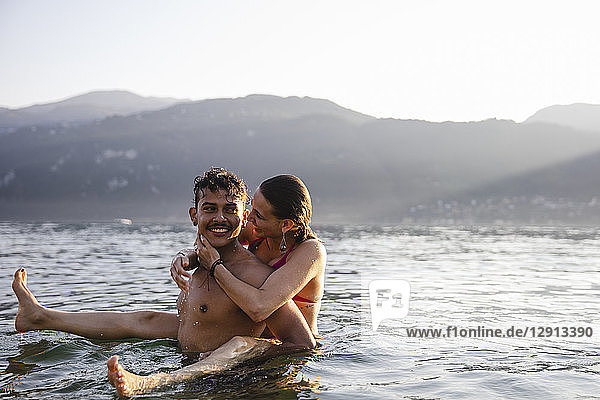 Happy playful young couple in a lake