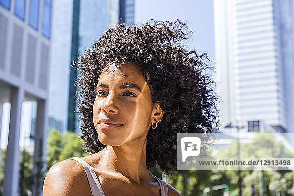 Germany  Frankfurt  portrait of content young woman with curly hair