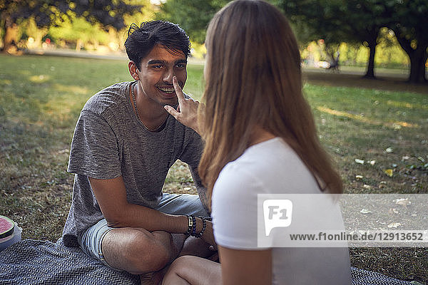 Young couple sitting in park  having fun