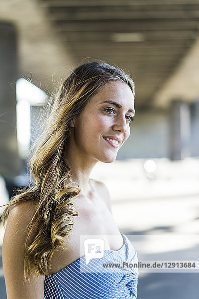 Portrait of smiling long-haired woman at underpass
