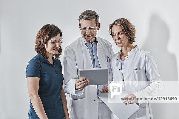 Doctors and medical secretary using tablet