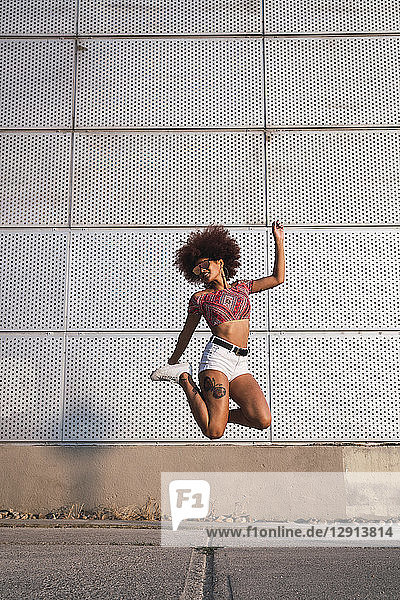 Fashionable young woman jumping in the air